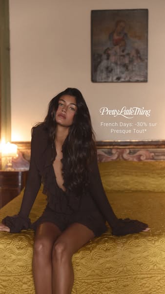 This image ad from PrettyLittleThing promotes a sale on most of their items. The ad features a model sitting on a bed in