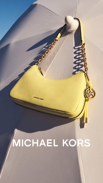This image ad features a Michael Kors bag hanging from what appears to be an umbrella. The brand name is visible in the