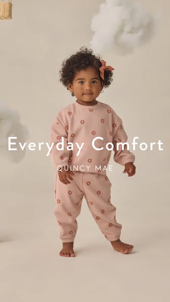This ad showcases a toddler modeling a matching sweatshirt and sweatpants outfit from Quincy Mae. The ad's visual st