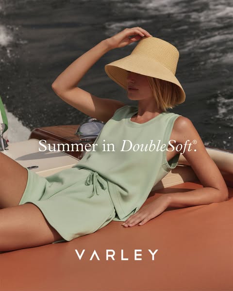 This ad features a woman lounging on a boat in a Varley DoubleSoft set, positioned as the ideal summer attire. The ad ai