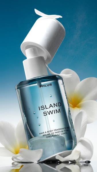 This image ad showcases the PHLUR Island Swim hair and body mist. The visual features a close-up of the product bottle w