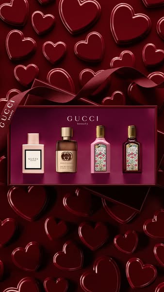 The ad displays a collection of four Gucci fragrances housed in a burgundy box that is wrapped with a matching Gucci-bra