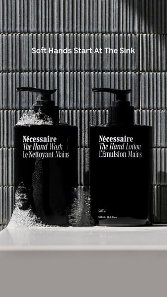 This ad showcases Nécessaire's The Hand Wash and The Hand Lotion in sleek, minimalist black bottles against a textur