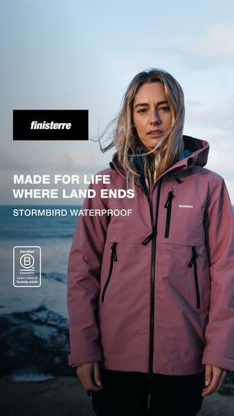 This ad features a woman standing on a rocky beach wearing a light pink Finisterre waterproof jacket. The ad highlights 