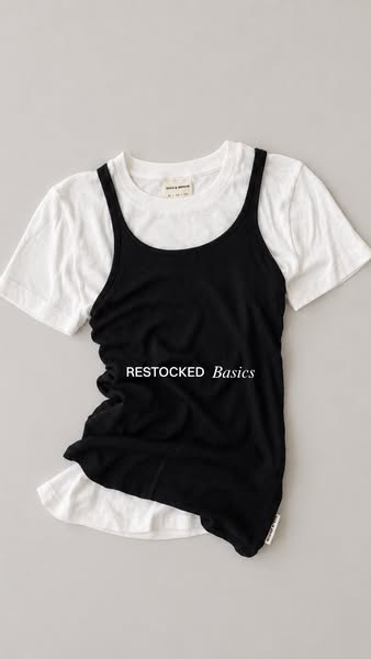 This image ad features a white t-shirt layered under a black tank top, with the overlay text 'RESTOCKED Basics'.