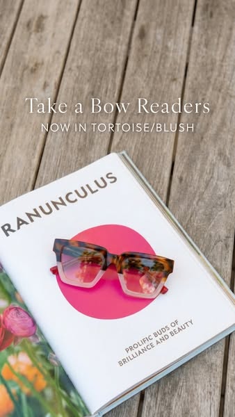 The ad is showcasing the new color of "Take a Bow Readers" reading glasses by placing them on a book.