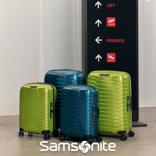 This ad showcases a collection of Samsonite suitcases in varying sizes and colors, arranged in front of a signpost that 
