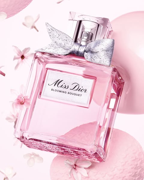This ad showcases a bottle of Miss Dior Blooming Bouquet fragrance. The image is an artistic shot of the product surroun
