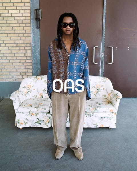An ad for OAS clothing featuring a model wearing an OAS shirt and pants.