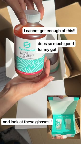 A woman shows off a bottle of Symprove daily live and active bacteria supplement and a set of shot glasses that come wit