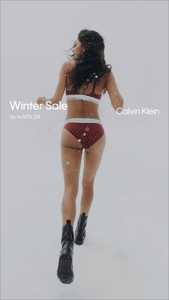 This ad for Calvin Klein promotes a winter sale with up to 50% off. It features a woman in Calvin Klein underwear walkin