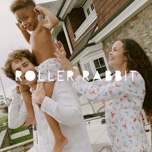 This ad features a family – a mother, father, and son – dressed in Roller Rabbit clothing in front of a house and car. T
