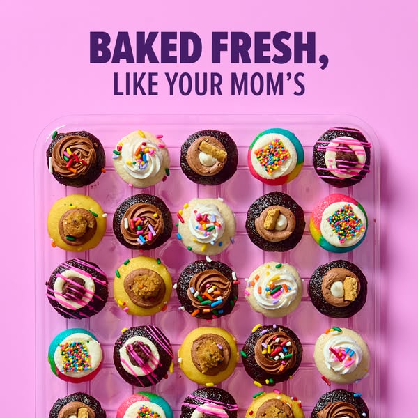 This image showcases a variety of frosted mini cookies from a bird's eye view in their plastic packaging. The cookie