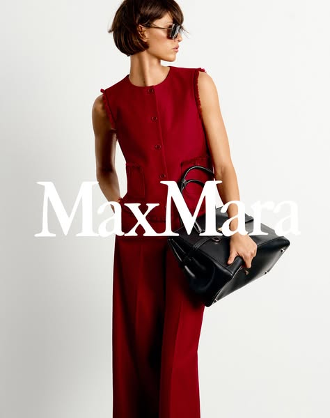 This image features a woman wearing a red pantsuit and carrying a black purse. The brand Max Mara is written across the 