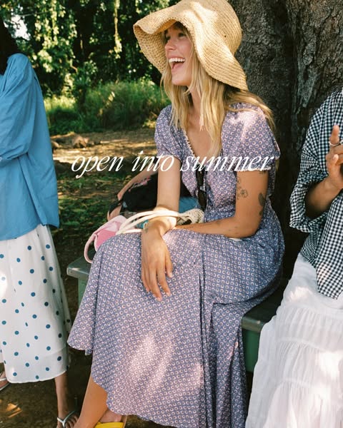 A lifestyle ad promoting a clothing brand. The ad shows three women sitting outside, wearing the brand's dresses and