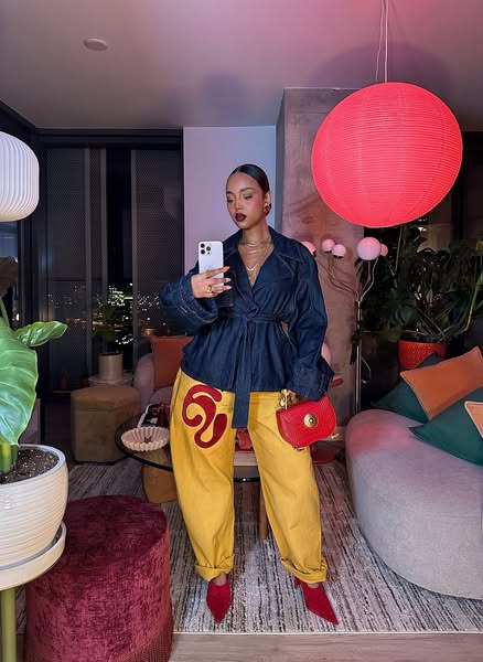 A photograph presents a creator showcasing her style in an indoor setting. The image highlights her fashion-forward look