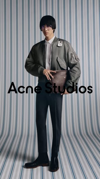 This ad features a full-body shot of a person wearing Acne Studios clothing and holding an Acne Studios bag. The ad is s
