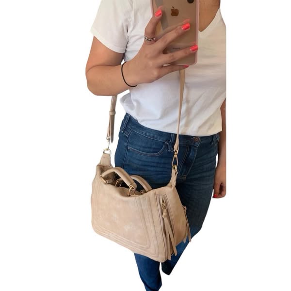 This ad showcases a woman modeling a satchel purse with a detachable shoulder strap, suggesting its adaptability.