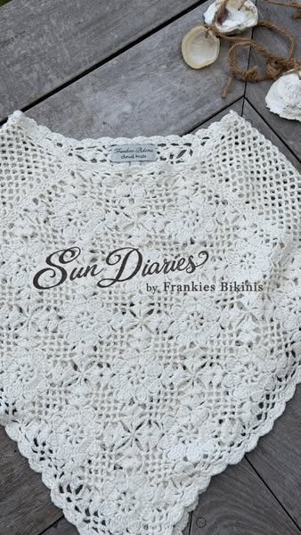This image promotes the Sun Diaries by Frankies Bikinis crocheted top. The product is placed flat on a wooden surface. S