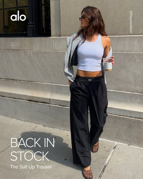 This ad showcases Alo Yoga's 'The Suit Up Trouser' on a model in an urban setting, emphasizing its stylish a