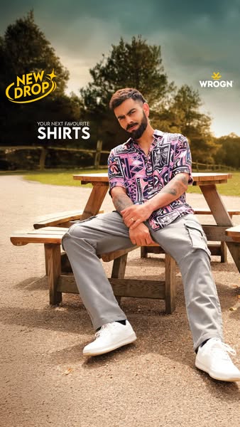 This image ad features Indian cricketer Virat Kohli sitting on a wooden picnic bench, wearing a WROGN shirt and promotin
