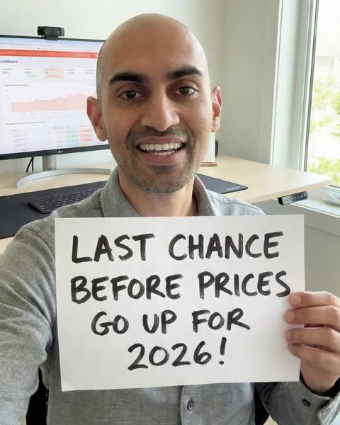 A man holds a sign announcing that prices will be going up in 2026.