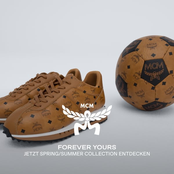 This ad showcases brown leather sneakers and a matching soccer ball, both patterned with the MCM logo. The ad promotes t