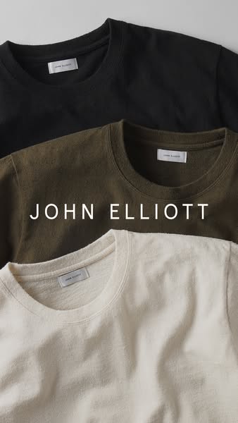 This ad showcases three different colored t-shirts from John Elliott. The shirts are stacked on top of each other, with 