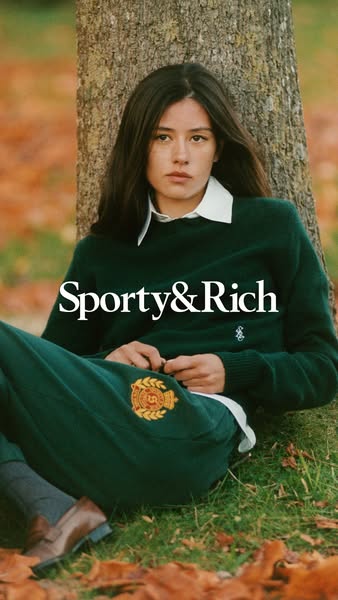 This image ad for Sporty & Rich features a person leaning against a tree wearing Sporty & Rich branded sweater a