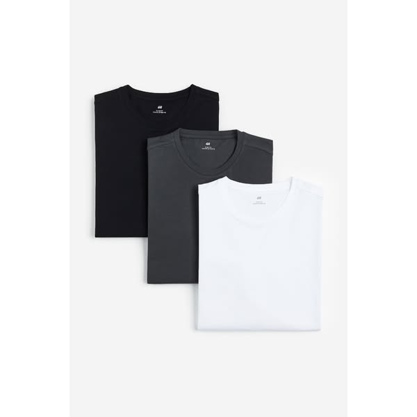 This ad features a stack of three folded H&M t-shirts in black, gray, and white, presented against a white backgroun