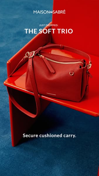 This image showcases a red handbag on a red display. The ad highlights the new 'Soft Trio' collection from Maiso