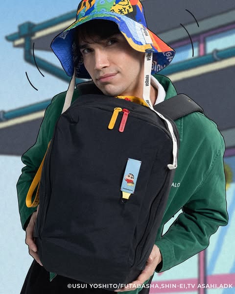 This ad features a model wearing a black backpack with colored zippers. The model is also wearing a colorful hat and a g