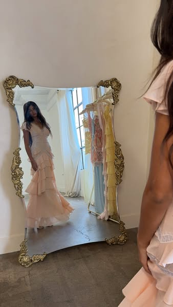 An image ad displays an ornate mirror reflecting a woman in a pink dress. A second pink dress and other dresses in paste