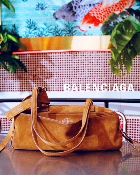 This ad showcases a Balenciaga handbag in a lifestyle setting, emphasizing the brand's luxury and style.