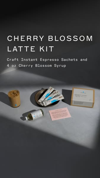 A product display showcasing a Blue Bottle Coffee Cherry Blossom Latte Kit against a gray background, highlighting the i