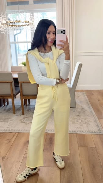 The ad features a woman taking a selfie while wearing a matching yellow sweat suit.