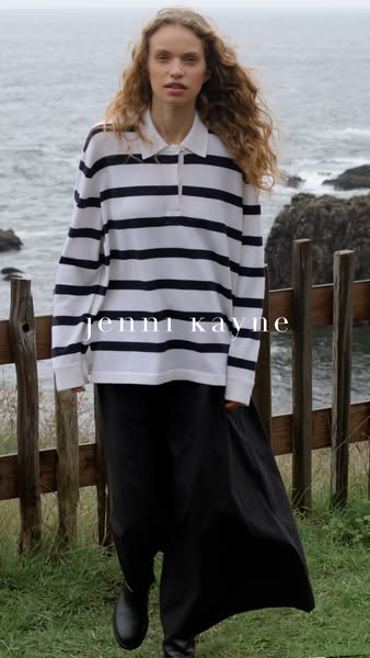 An image ad for Jenni Kayne featuring a woman wearing the Striped Cotton Rugby shirt. The woman is standing on a walking