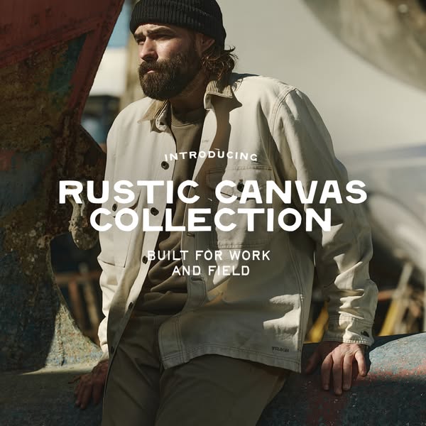 This image ad showcases a person leaning on a rusted object wearing clothes from the Rustic Canvas Collection.