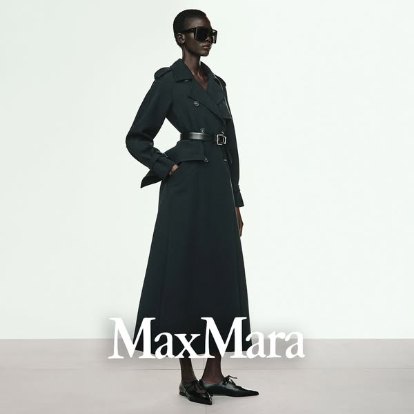 This ad features a full-length shot of a model wearing a Max Mara trench coat, styled with a belt and black shoes. The b