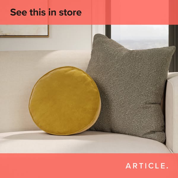 This ad by Article features a round yellow pillow and a square grey pillow on a white couch.