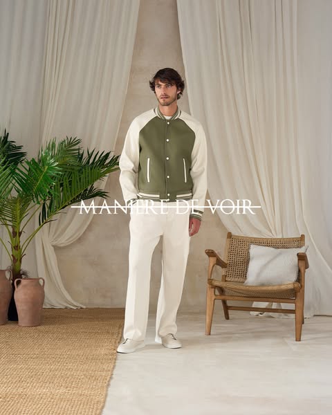 This ad features a man wearing a bomber jacket and white pants in a lifestyle setting to promote the brand Manière De Vo