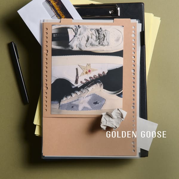 This ad features a single still image of luxury sneakers, positioned within an office setting. The sneakers are the foca