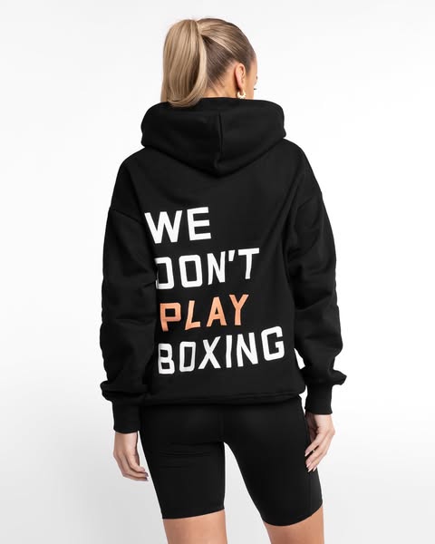 This ad features a woman wearing a black hoodie and biker shorts. The hoodie has the text "WE DON'T PLAY BOXING