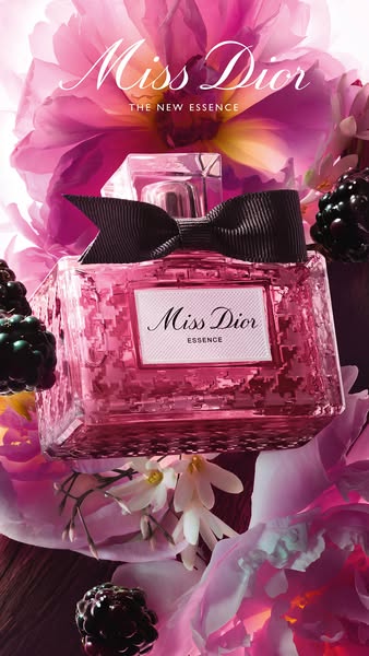 An ad showcasing the Miss Dior Essence perfume with a focus on the visual presentation of the product alongside berries 