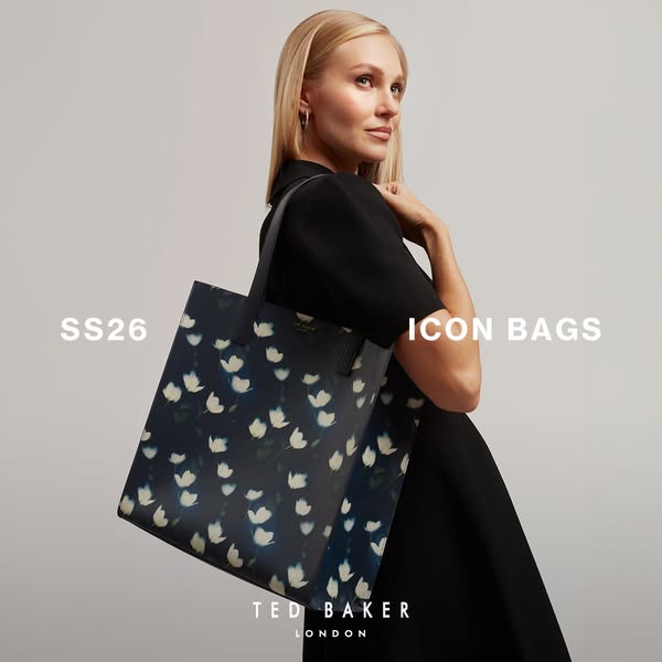 This ad showcases a single, floral print Ted Baker London tote bag. A fair-skinned model with blonde hair is shown weari