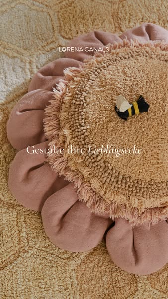This image ad showcases a decorative, flower-shaped rug with a small bee toy on it. The ad encourages viewers to design 
