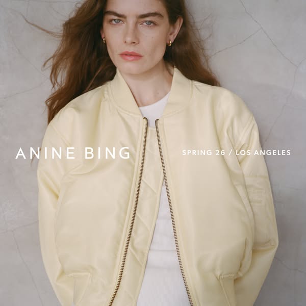 This ad features a woman wearing a light yellow bomber jacket by Anine Bing. The ad has a simple and clean aesthetic.