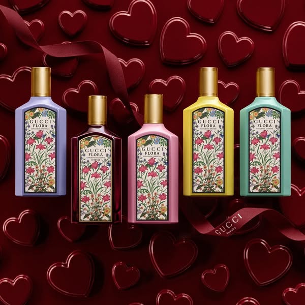 An ad for Gucci Flora perfumes, featuring multiple scents against a Valentine's Day-themed background. The image sho