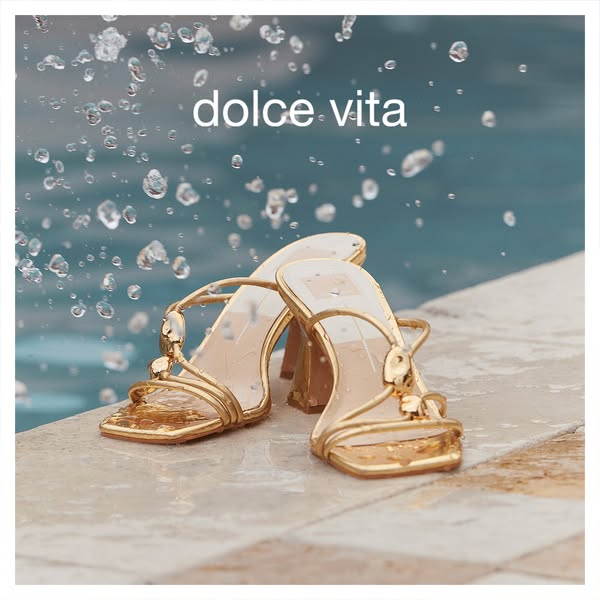 This ad showcases Dolce Vita sandals on the edge of a pool, with water splashing for a luxurious feel.