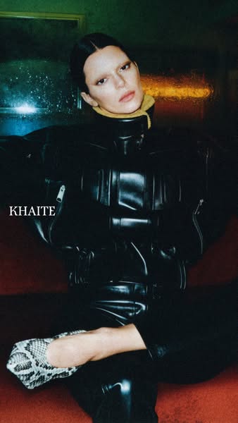 This ad features a stylish woman modeling Khaite clothing in an urban setting, emphasizing the brand's high-fashion 